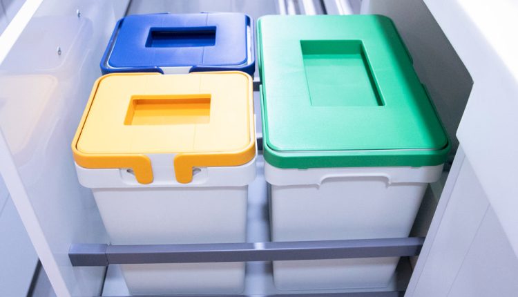 W małej kuchni schludne kosze segregują odpady pod blatem