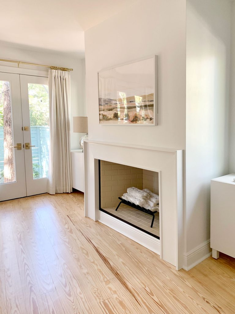 kominek betonowy w wnętrzu kominek z szlifowanego betonu z delikatnymi płomieniami i drewnianymi akcentami