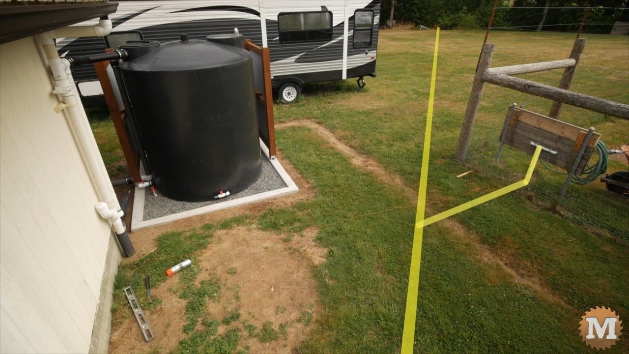 podłączanie rur do zbiornika deszczówki mężczyzna łączący rury PCV od rynny do zbiornika podziemnego