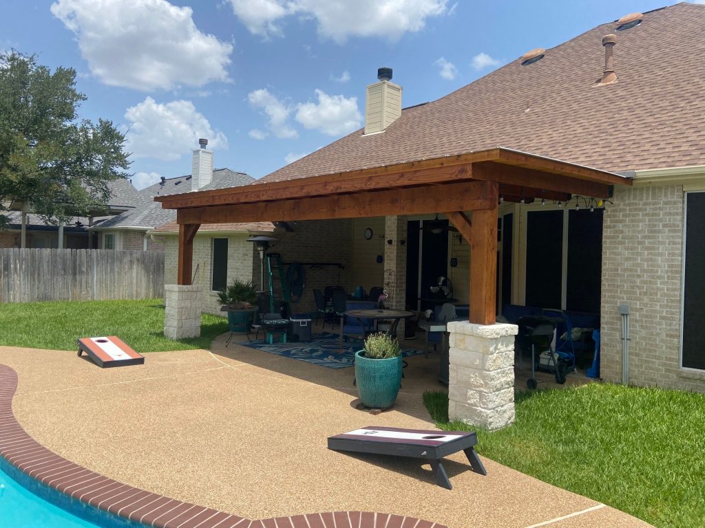 Mężczyzna testujący mechanizm markizy pilotem z cieniem na podłodze tarasu