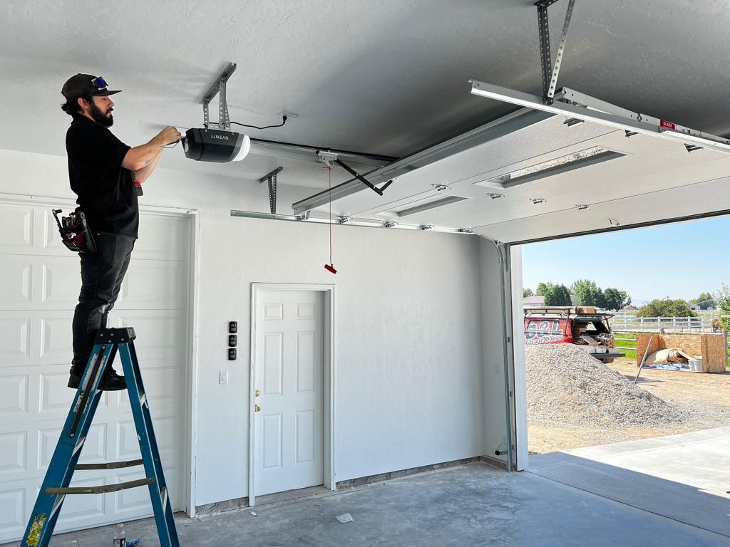 montaż napędu elektrycznego bramy podłączanie silnika elektrycznego do sufitu nad bramą garażową