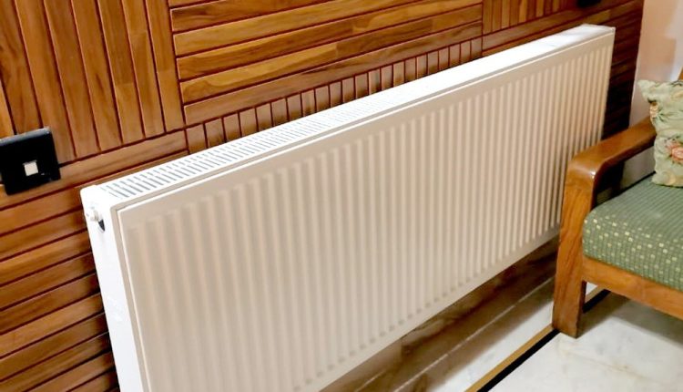 nowoczesny salon z ciepłą podłogą obok pokoju z grzejnikami na ścianie