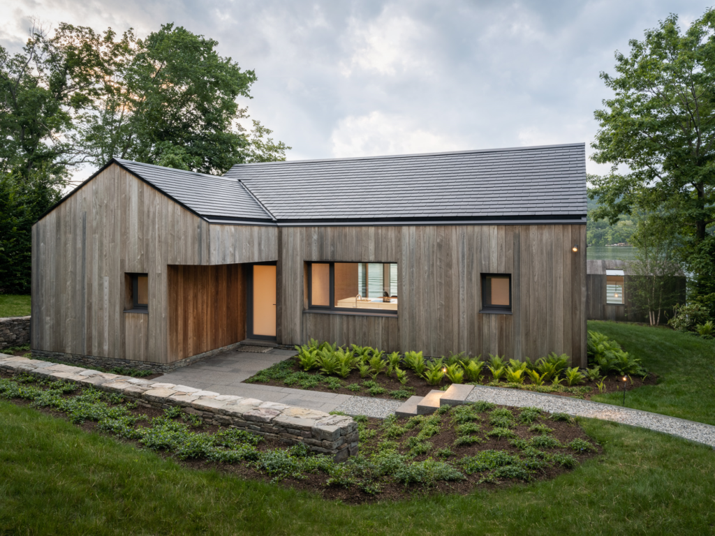 robotnicy układający wełnę mineralną na zewnętrznych ścianach budynku w trakcie budowy