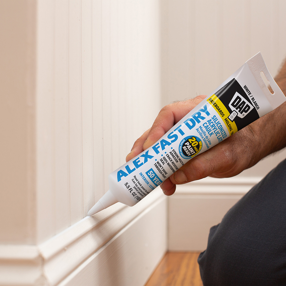 aplikator pistoletowy wyciska silikon na fugę między płytkami