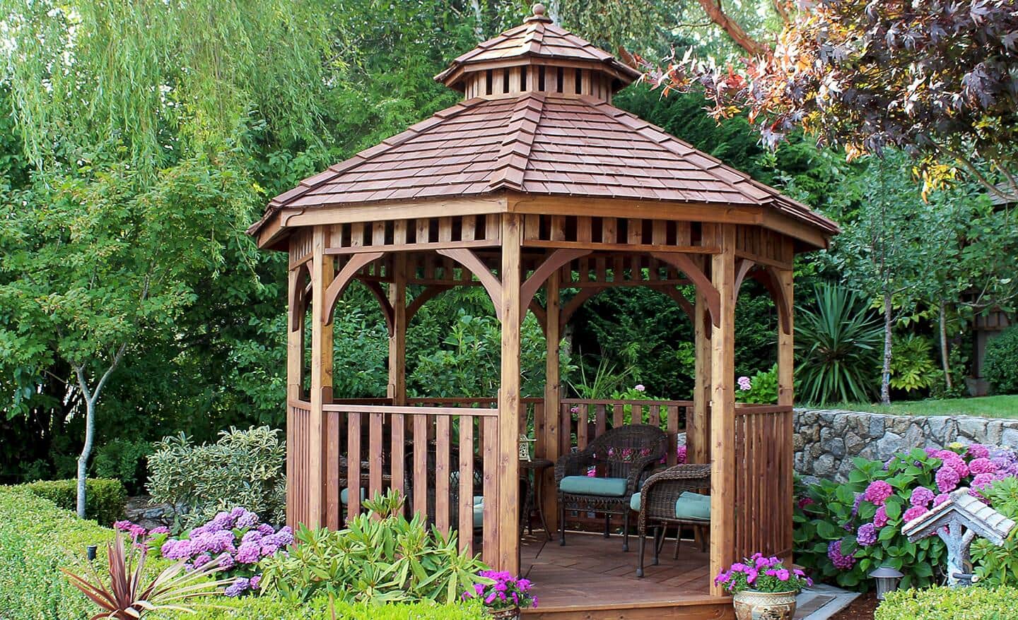 kobieta malująca pędzlem drewnianą balustradę altany na zewnątrz