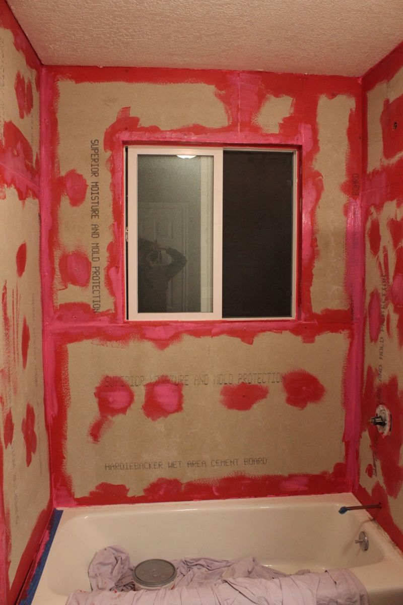 montaż płyt gipsowo-kartonowych na ścianie łazienki z folią ochronną i śrubami